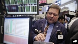 In this Sept. 9, 2011 photo, trader John Santiago works on the floor of the New York Stock Exchange.