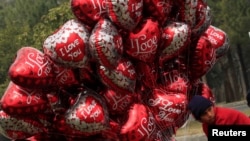 FILE: A boy sells heart-shaped balloons on Valentine's Day, February 14, 2017.