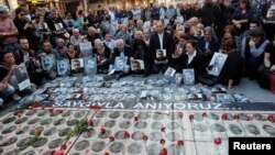FILE - Human rights activists hold portraits of victims during a demonstration to commemorate the 1915 mass killing of Armenians in the Ottoman Empire, in central Istanbul, Turkey, April 24, 2018. 
