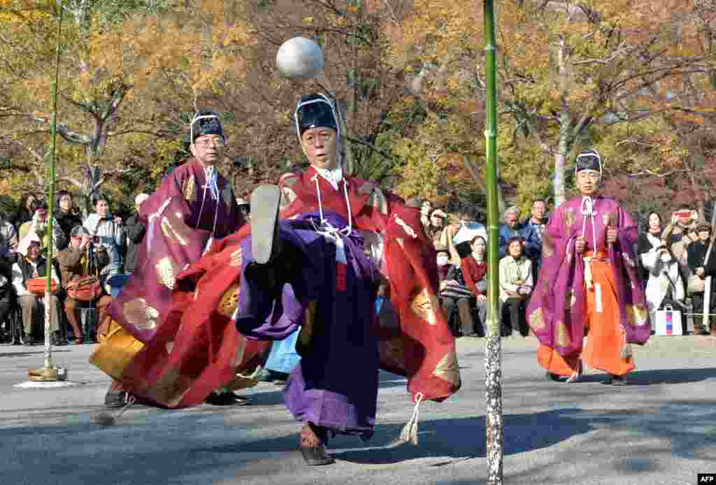 Wearing ancient Japanese costumes, participants play "kemari," an ancient ball-lifting game using only their right legs in Tokyo.