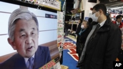 People watch a television broadcasting Japan's Emperor Akihito's televised address to the nation at an electronics retail store in Tokyo, March 16, 2011.