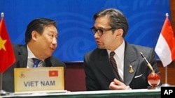Vietnamese FM Pham Gia Khiem (L) talks with his Indonesian counterpart Marty Natalegawa (R) during an ASEAN signing ceremony in Hanoi, 27 Oct 2010