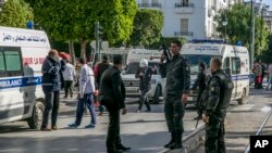 FILE - Tunisian police officers secure the site of an attack after a 30-year-old woman blew herself on the Habib Bourguiba avenue in Tunis, Tunisia, Oct. 29, 2018.
