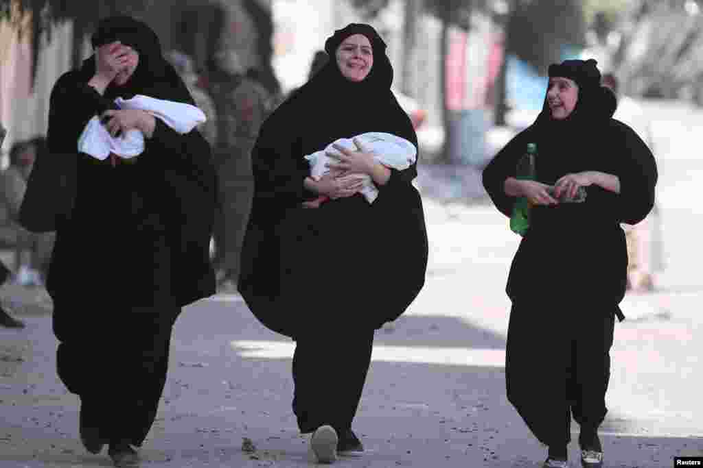 Women carry newborn babies while reacting after they were evacuated by the Syria Democratic Forces (SDF) fighters from an Islamic State-controlled neighborhood of Manbij, in Aleppo Governorate, Syria, Aug. 12, 2016. 