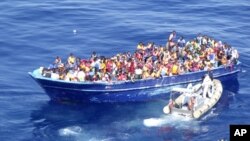 Perahu yang berisi puluhan migran dihampiri oleh penjaga pantai Italia di Laut Tengah (22/8).