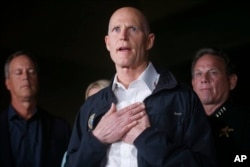 FILE - Florida Gov. Rick Scott gestures as he speaks during a news conference near Marjory Stoneman Douglas High School in Parkland, Fla., Feb. 14, 2018.