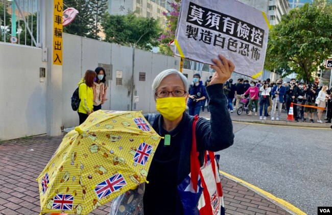 64岁的示威者黄婆婆手持标语及黄伞12月2日到西九龙裁判法院外声援被判入狱的黄之锋、林朗彦及周庭。