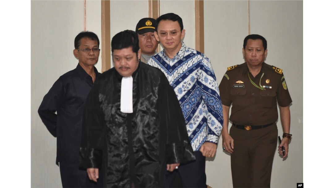 Jakarta Governor Basuki "Ahok" Tjahaja Purnama, center, is escorted by prosecutors as enters the court room for his sentencing hearing in Jakarta, Indonesia, May 9, 2017.