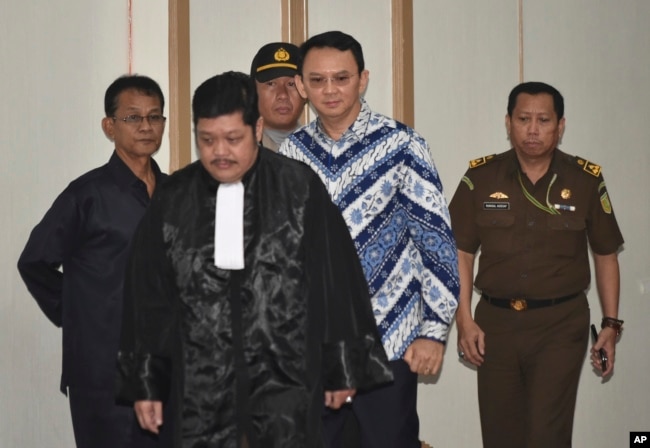 Mantan Gubernur Jakarta Basuki "Ahok" Tjahaja Purnama, tengah, dikawal Jaksa Penuntut saat memasuki persidangan penodaan agama di Jakarta, 9 Mei 2017.