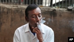 FILE- An Indian man smokes a cigarette in New Delhi, India, Nov. 3, 2016.