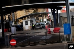 A Gibraltarian police officer talks with the driver of a car crossing the border of Spain with Gibraltar in the British overseas territory of Gibraltar.