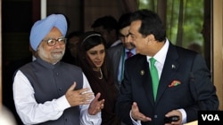 PM India Manmohan Singh (kiri) berbincang dengan PM Pakistan Yousuf Raza Gilani di sela-sela konferensi SAARC di Maladewa (10/11). Singh dikecam kelompok Hindu karena menyebut PM Gilani 'cinta damai'.