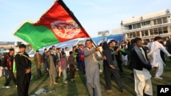 FILE - Afghan cricket fans celebrate the victory of the national cricket team over Zimbabwe as the team returns and celebrates in Kabul, Afghanistan, Oct. 30, 2015.