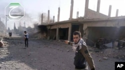 A citizen journalism image provided by Qusair Lens shows a Qusair-based activist walking on a street hit by the shelling of Hezbolllah and the Syrian forces loyal to Syrian President, in Qusair, near the Lebanon border, May 31, 2013.