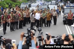 Indonesian President Joko Widodo, center, in white shirt, visits the site of a bomb blast at Thamrin business district in Jakarta, Jan. 14, 2016.