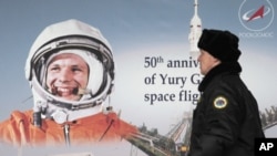 A man passes a portrait of Yuri Gagarin during a ceremonial reception, dedicated to the upcoming Day of Aviation and Cosmonautics and the 50th anniversary of Gagarin's historic first space flight celebrated on April 12, in Moscow, April 11, 2011.