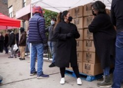 Sukarelawan Gloria Martinez (kiri) berbincang dengan Sofia Moncayo dalam pembagian bantuan makanan di Gereja Mosaic West Queens, kawasan Sunnyside, Queens, New York, 22 Februari 2021. (Foto: dok).
