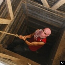 A Palestinian smuggler uses a rope to climb out of a tunnel linking the southern Gaza Strip town of Rafah with Egypt (File)