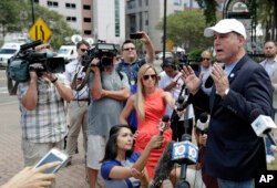 El candidato demócrata a la gobernación de Florida Philip Levine, (derecha) habló con la prensa cerca del lugar del mortal tiroteo en Jacksonville, el 27 de agosto de 2018.