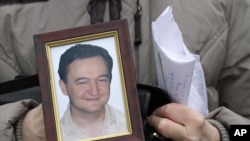 FILE - Photo of a portrait of lawyer Sergei Magnitsky who died in Russian jail.