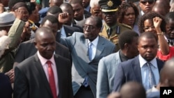 Zimbabwean President Robert Mugabe, centre, gestures after addressing members of the Zimbabwe National Liberation War Veterans Association, at the party headquarters, in Harare on July, 27, 2016. 