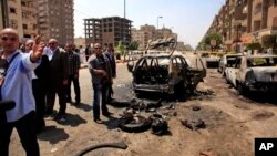 Les agents de sécurité a proximité d'une voiture endommagée par une bombe à Nasr City, au Caire, Egypte, 5 Sept., 2013. 