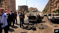 Petugas keamanan Mesir memeriksa sebuah mobil yang hancur akibat ledakan bom di Kairo, Kamis (5/9). 