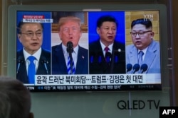 FILE - People watch a screen showing images of, from left, South Korea's president Moon Jae-in, U.S. president Donald Trump, China's president Xi Jinping, and North Korea's leader Kim Jong Un at a railway station in Seoul, May 11, 2018.