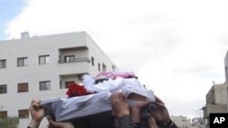 In this citizen journalism image made on a mobile phone and acquired Saturday April 23, 2011, by The AP, Syrian anti-government protesters carry the coffin of an activist who was killed on Friday during his funeral procession in Quaboun near Damascus, Syr