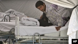 A Syrian refugee waits for medical assistance on a bed in a field hospital set up by the Turkish Health Ministry in a camp in Yayladagi ,Turkey, near the Syrian border, Sunday, June 12, 2011.