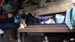 Ivorian toddlers Prencia Gosse, left, and Laure Djiejian, who along with their families fled ethnic and political clashes, play alongside piled belongings in a classroom at the Catholic Mission in Duekoue, in western Ivory Coast (File Photo - May 30, 2011