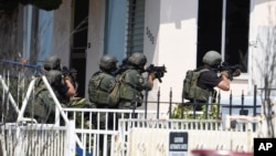San Diego Police SWAT officers prepare to enter house with a possible suspect inside in San Diego, July 29, 2016. 