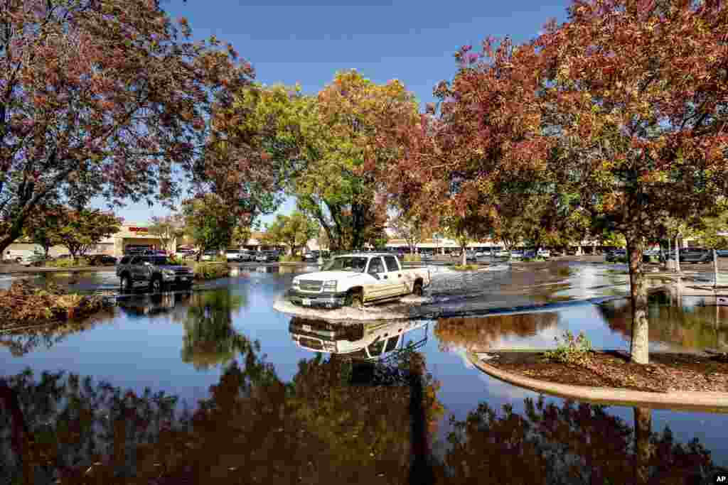 A pickup truck crosses a flooded parking lot in Oroville, Calif., Oct. 25, 2021.&nbsp;A massive storm barreled toward Southern California after causing flooding across the northern half of the state.