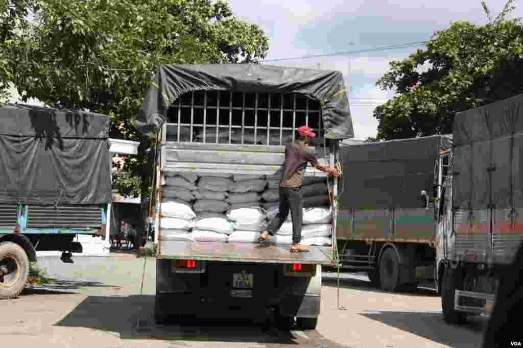 Workers close up a truck full of rice bags, Tien Giang, Vietnam, September 14, 2012. (D. Schearf/VOA)