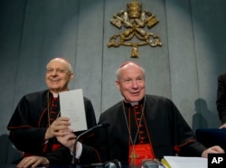 Cardinals Lorenzo Baldisseri, left, and Christoph Schoenborn show a copy of the post-synodal apostolic exhortation ' Amoris Laetitia ' (The Joy of Love) during a press conference at the Vatican, April 8, 2016.