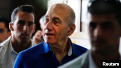 FILE - Former Israeli Prime Minister Ehud Olmert (center) leaves Tel Aviv District Court, May 13, 2014. Olmert was sentenced to six years in jail on Tuesday for taking bribes in a massive real estate deal.