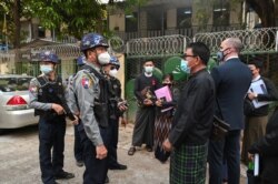 Polisi dan pengacara terlihat di luar pengadilan kota Kamayut di mana sidang sekelompok jurnalis yang ditahan selama protes anti-kudeta dijadwalkan, termasuk jurnalis Associated Press Thein Zaw, di Yangon 12 Maret 2021.