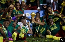 Cameroon players celebrate with the trophy after winning the African Cup of Nations final soccer match between Egypt and Cameroon at the Stade de l'Amitie, in Libreville, Gabon, Sunday, Feb. 5, 2017. Cameroon won 2-1.