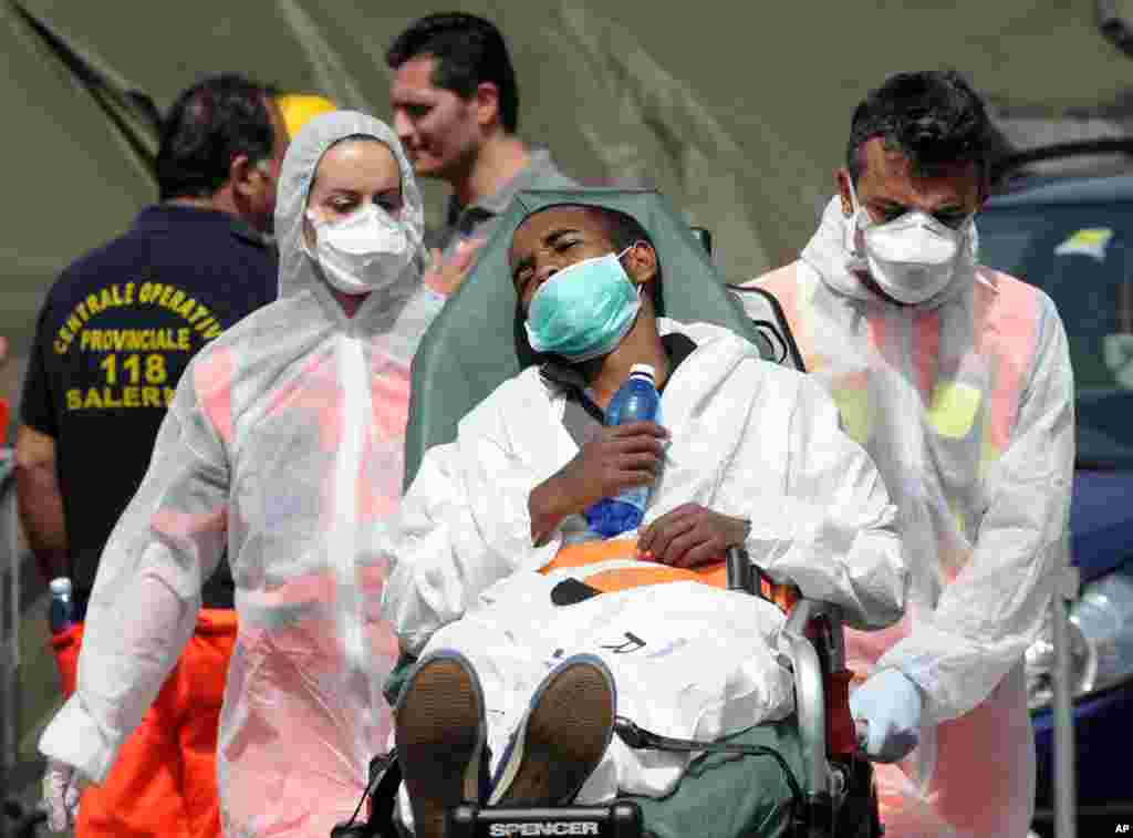 A migrant is carried on a stretcher after disembarking from the Italian Navy vessel Bettica in the harbor of Salerno, Italy, May 5, 2015. 