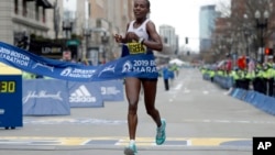 Worknesh Degefa, of Ethiopia, breaks the tape to win the women's division of the 123rd Boston Marathon on April 15, 2019, in Boston. 