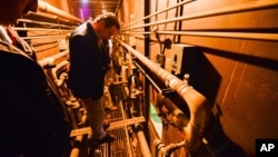 This photo provided by the New York state governor's office shows Gov. Andrew Cuomo on a catwalk, looking into the cell that inmates escaped from at a maximum-security prison in Dannemora, N.Y., June 6, 2015. 