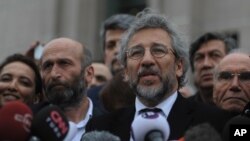 Can Dundar, the editor-in-chief of opposition newspaper Cumhuriyet, right, and Erdem Gul, left, the paper's Ankara representative, speak to the media after their trial in Istanbul, March 25, 2016.