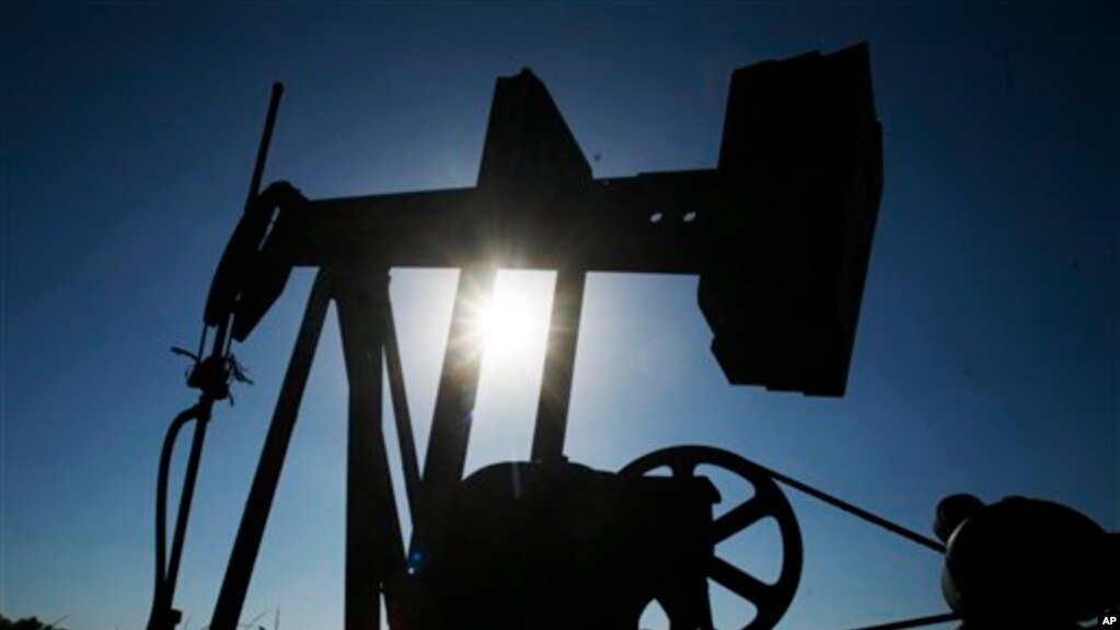 An oil well pumps under the summer sun in a field near Rantoul, Kan., Friday, July 1, 2011.