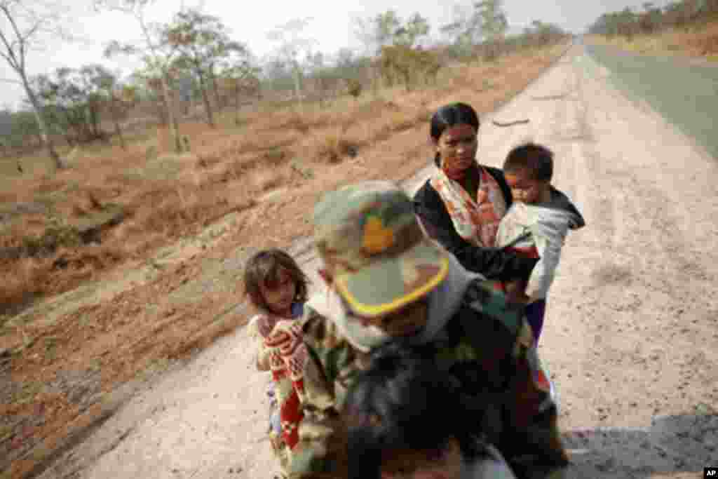 A Cambodian family is seen on an empty road as they flee the area near the 11th-century Preah Vihear temple at the border between Thailand and Cambodia February 7, 2011. Thai and Cambodian troops clashed for a fourth straight day on Monday over a disputed