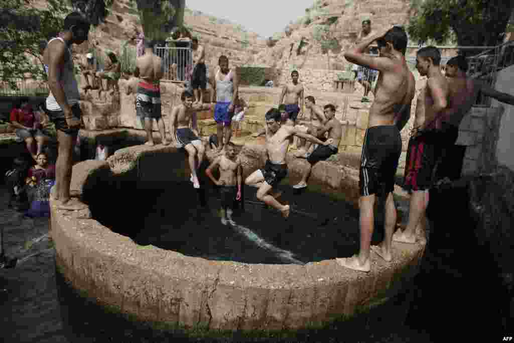 Palestinians and Israelis bathe in a natural spring in Ein Fawwar, near the West Bank city of Jericho, on Aug. 3, 2015, as temperatures in the Jordan valley reached 48 degrees Celsius (118.4 Fahrenheit).