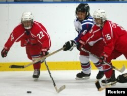 FILE - A South Korean player (white jersey) struggles for the puck during a women's ice hockey match at the fifth Winter Asian Games in Misawa, Japan, Feb. 3, 2003. Seoul has proposed a joint North-South Korean women's hockey team for the Pyeongchang Olympics next month.