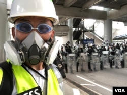 美国之音记者在香港机场报道香港反中民众机场示威防暴警察清场的实况。（美国之音记者黎堡拍摄）