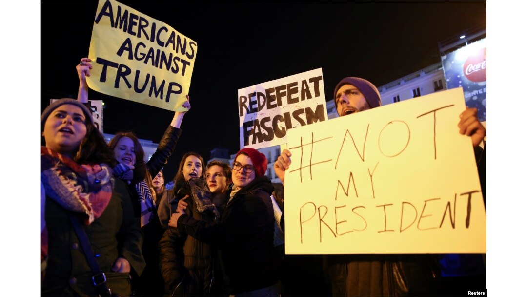 Anti-Trump protesters hold banners during a demonstration at Puerta del Sol Square in Madrid, Spain, Dec. 2, 2016.