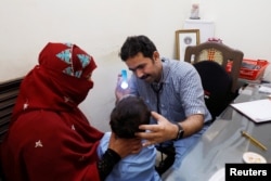 Dr Imran Akbar Arbani, performs a routine medical check-up of a four-year-old HIV positive boy, at clinic in Ratodero, Pakistan May 24, 2019. (REUTERS/Akhtar Soomro)