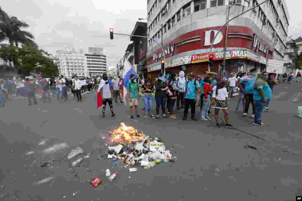 Estudiantes universitarios bloquean una calle frente a la Asamblea Nacional y incendian basura para protestar por las reformas constitucionales propuestas en la Ciudad de Panamá. 